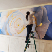 Yohanna Jessup on a ladder creating a large scale painting.
