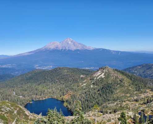 a landscape with mt shasta, castle lake, mountians and tees